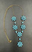 A silver gilt turquoise set flower cluster necklace on a 9 carat gold chain.