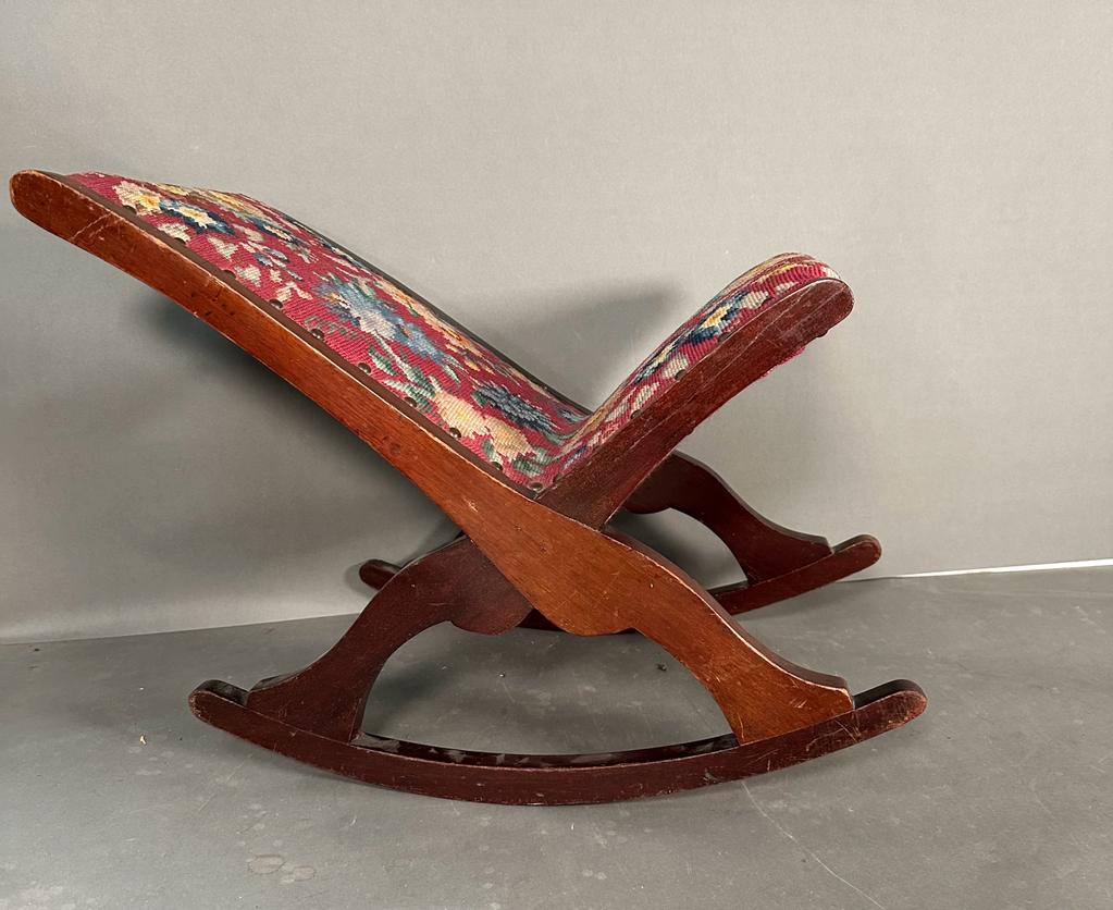 A vintage floral upholstered rocking footstool