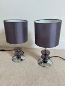 A pair of contemporary bedside lamps