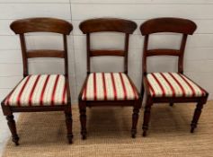 Three mahogany dining chairs with stripe seat pads