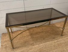 A mid-century brass smoked glass topped coffee table. Height 42 and 45x90