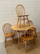 A Circular blonde Ercol table and chairs