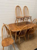 Blonde Ercol dining table with six hoop back chairs and two extra leaves