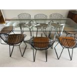 A set of eight Harry Bertoia chairs with brown leather seat pads and a Merrow Associates glass table