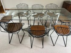 A set of eight Harry Bertoia chairs with brown leather seat pads and a Merrow Associates glass table
