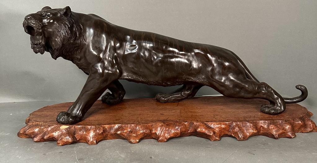 A large bronze lion on stand Japanese Meiji period 19th Century (H32cm W77cm)