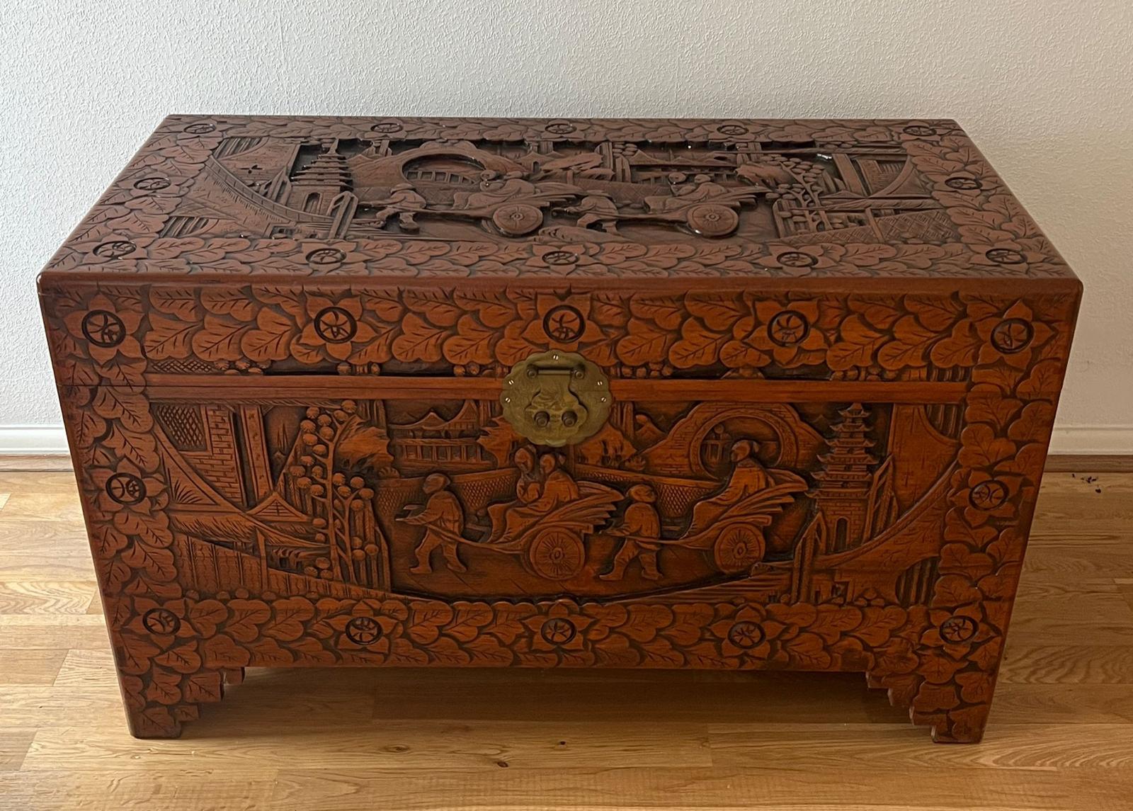 An ornately carved camphor wood chest (H 60cm x D 50cm x W 102cm)