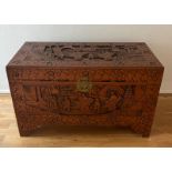 An ornately carved camphor wood chest (H 60cm x D 50cm x W 102cm)