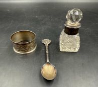 A small selection of silver items to include a scent bottle, napkin ring and spoon, various makers