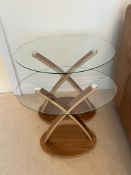 A pair of nesting tables with oval glass and cross frame (H57cm W60cm D44cm)