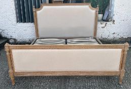 A louis style king size double bed upholstered in a beige linen by Loaf