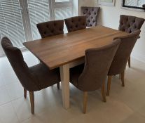 An extending dining room table with light oak top on white legs open to a centre leaf and eight