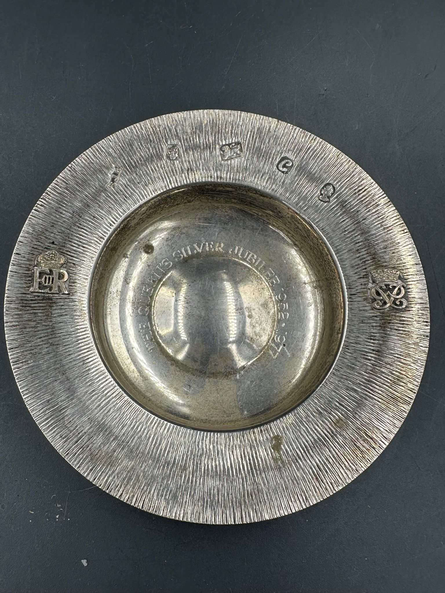 A silver ashtray with textured decoration and Queen Elizabeth II cipher by S J Rose & Son and