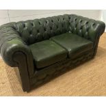 A two seater green button back sofa