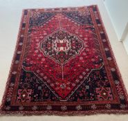 A red ground geometric rug (250cm x 172cm)