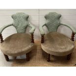 A pair of oak framed Victorian salon chairs upholstered in green with barley twist legs and arm