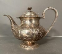 A Georgian silver teapot with repousse decoration and later handle, hallmarked for London, makers