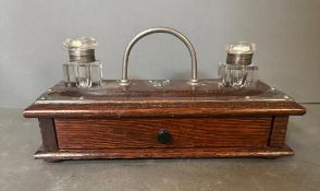 An oak ink stand or desk tidy with two ink wells and drawers under