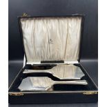 A boxed set of silver dressing table brush, mirror and comb with GE engraving, hallmarked for