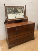 An Edwardian mahogany two over three chest of drawers with a two drawer bevel edged mirror unit (