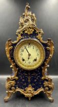 A Rococo style mantel clock with enamel face in royal blue with gilt fleur detail