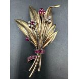 A yellow gold spray brooch set with rubies and diamonds.