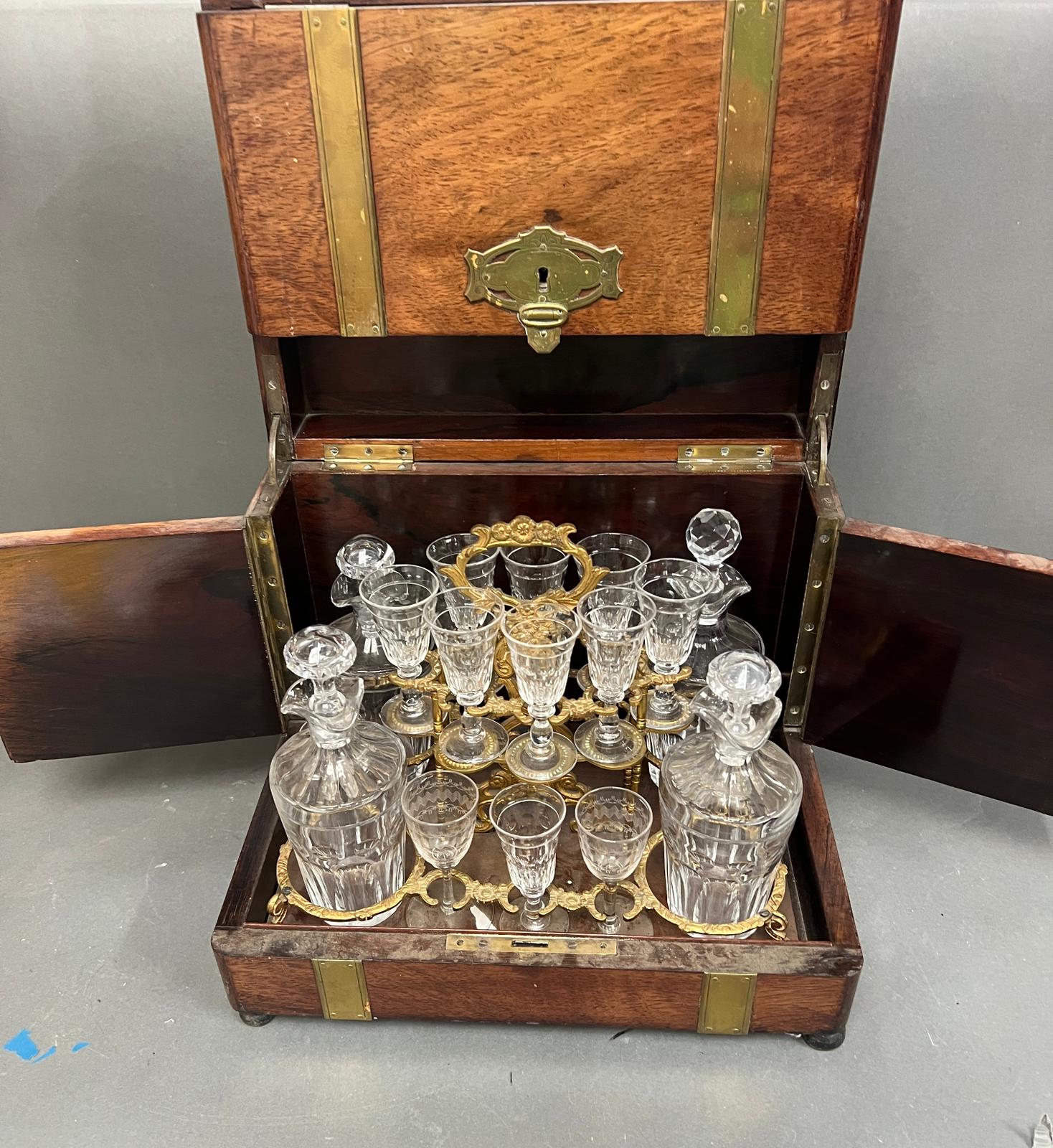 A wood and brass liquor cabinet with belt style straps, containing carafes and glasses.(32cm x - Image 4 of 5