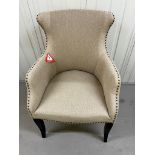 A contemporary linen armchair with studded detail