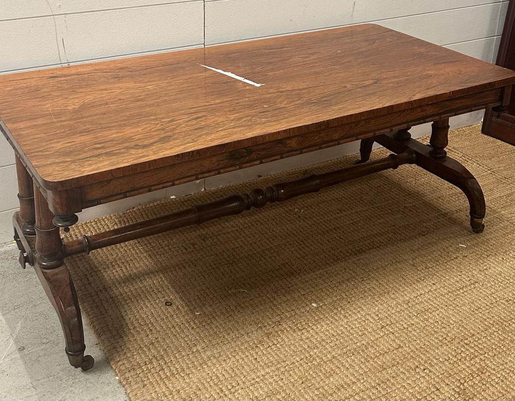 A substantial coffee table on down swept legs on castors with a turned cross stretcher AF H49cm
