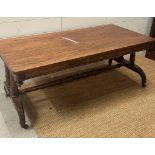 A substantial coffee table on down swept legs on castors with a turned cross stretcher AF H49cm