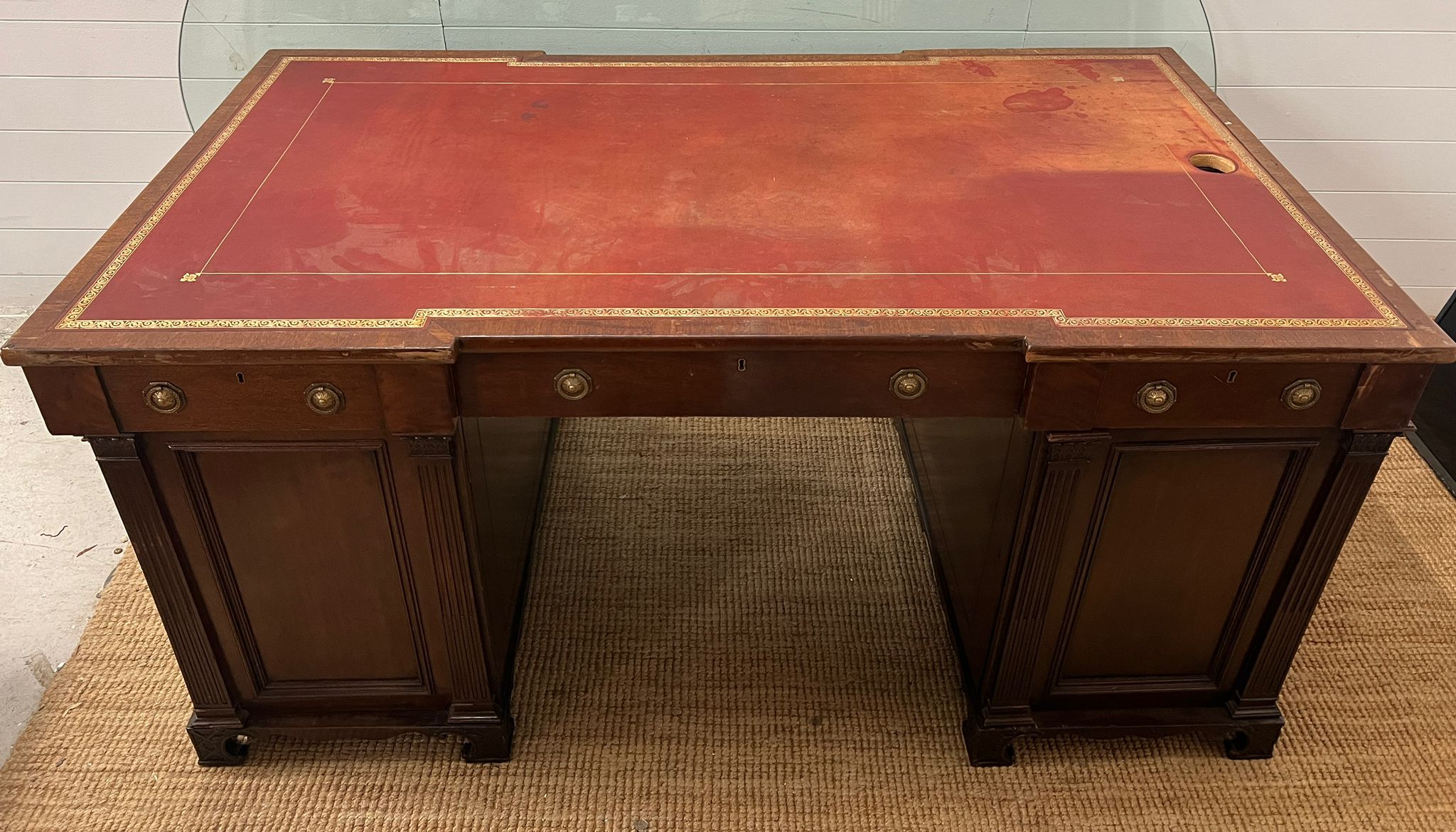 A early 20th Century double pedestal desk mahogany partners desk with a gold tooled red leather