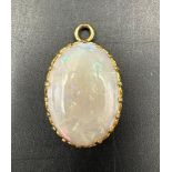 An opal pendant in a yellow gold setting AF