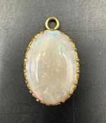 An opal pendant in a yellow gold setting AF