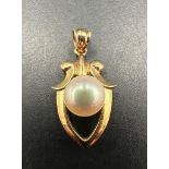 A Tasaki 14ct gold shield pendant with central Akoya pearl