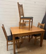 A single leaf oak dining table and four chairs