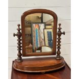A Mahogany bathroom mirror on turned supports and demi lune base