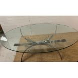 A contemporary glass dining table on brushed chrome sculptural legs (210cm x 128cm x 75cm)