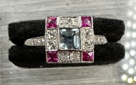 Platinum aquamarine, diamond and ruby square ring with diamond shoulders.