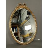 An oval wooden gold painted wall hanging mirror (50cm x 71cm)