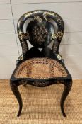 An Ebonised inlay chair with cane seat