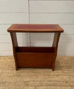 A teak magazine rack with red leather top