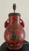 A red ground Oriental vase with ornate dragon design and dragon head handles. H 44cm