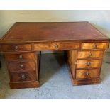 A pedestal partners desk with red leather inset with tooled decoration and lion head draw pulls,