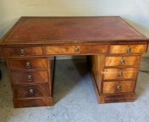 A pedestal partners desk with red leather inset with tooled decoration and lion head draw pulls,