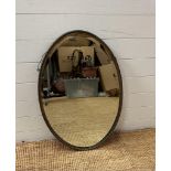 An oval metal framed bevel edged hall mirror (52cm x 78cm)