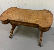 A Burr Elm Regency period library / writing table having rectangular lobed-end top above ormolu-