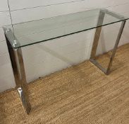 A glass console table on chrome legs (110cm W x 35cm D x 75cm H)