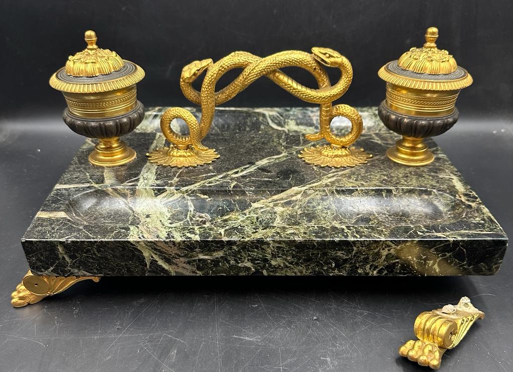An inkwell in bronze and marble on lion paw feet with twisted snake handle (One foot needs