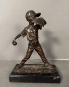 A hot cast bronze of a child playing baseball signed Nick and mounted on a marble plinth