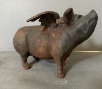 A decorative cast iron flying pig H19cm W31cm D21cm